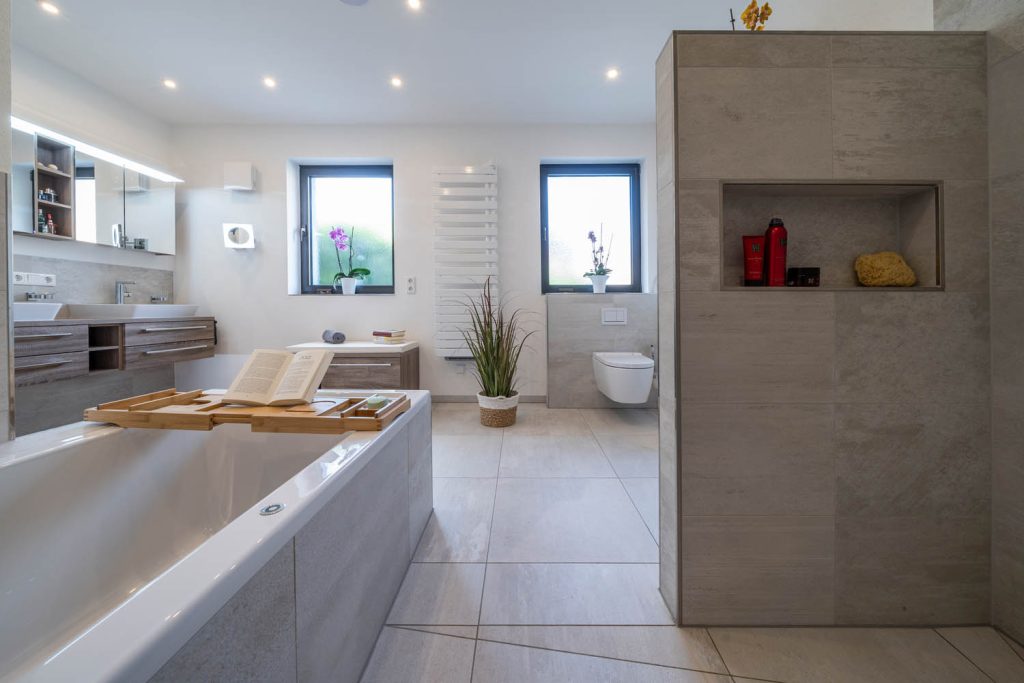 Raumansicht mit Badewanne, Trennwand mit Nische und Wand-WC