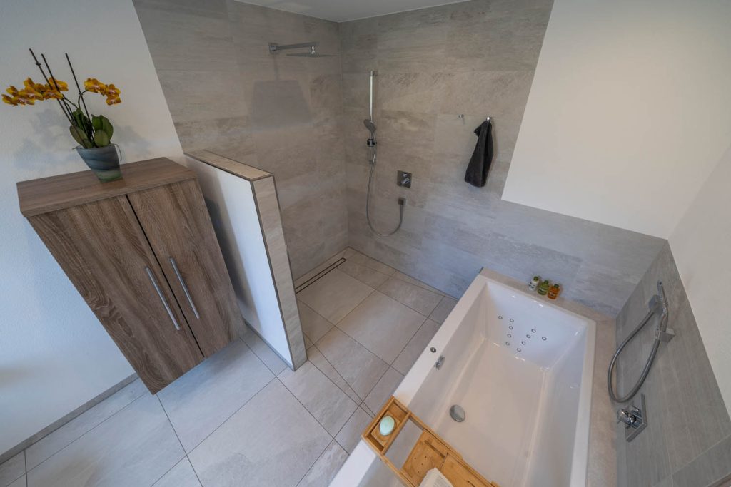 Blick von oben auf Dusche, Hängeschrank und Badewanne