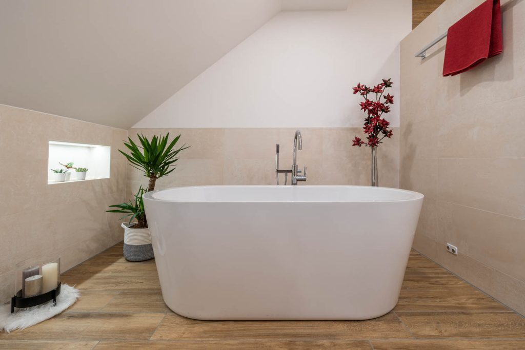 Badewanne unter der Dachschräge mit Pflanzen und beleuchteter Nische