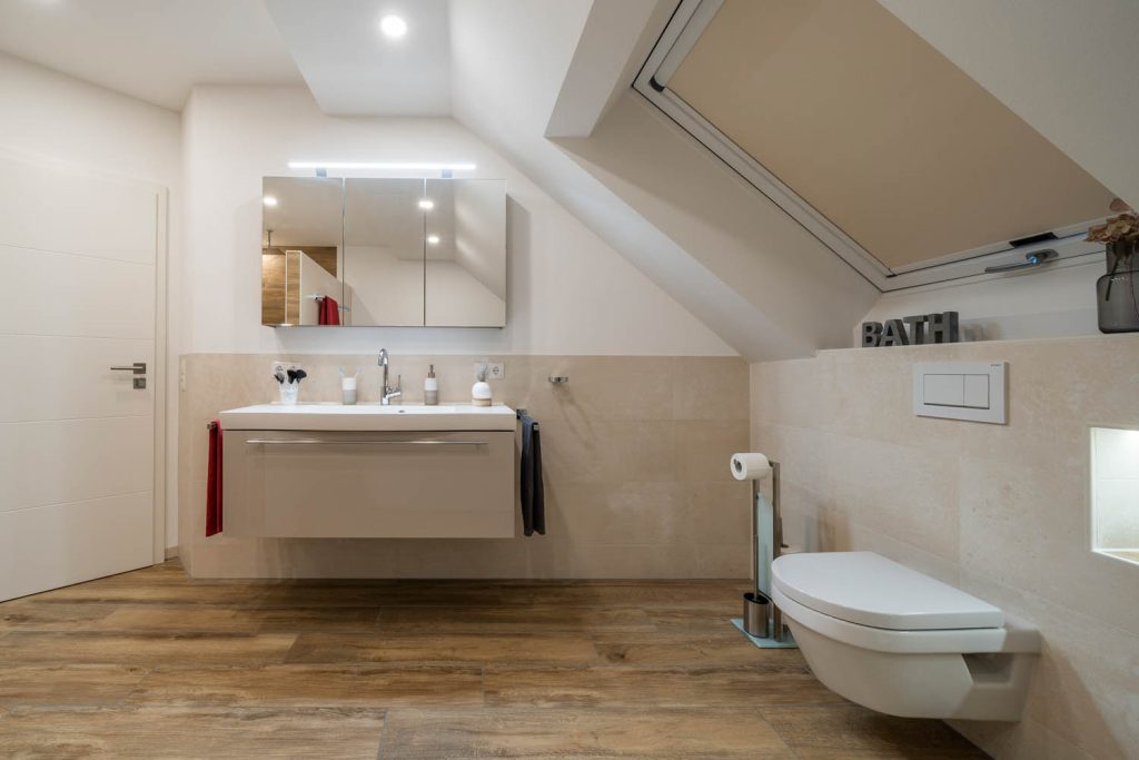 Waschtisch und Wand-WC unter der Dachschräge mit großem Dachfenster