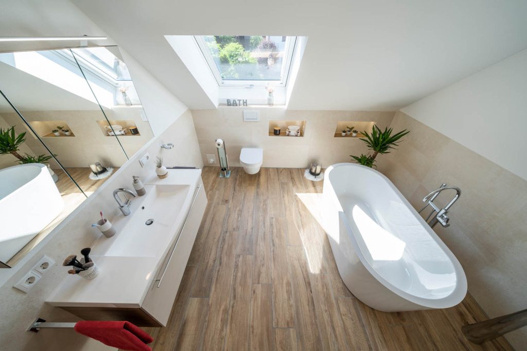 Blick von oben über Waschtisch und freistehende Wanne unter dem Dachfenster