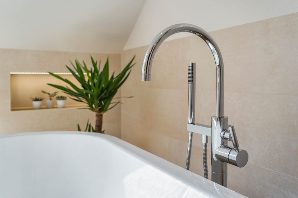 Standarmatur mit Handbrause an der freistehenden Wanne