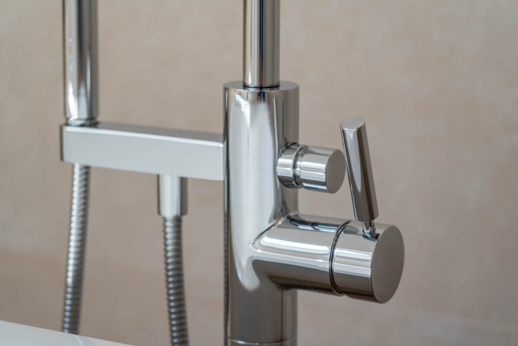 Detail der verchromten Standarmatur mit Handbrause