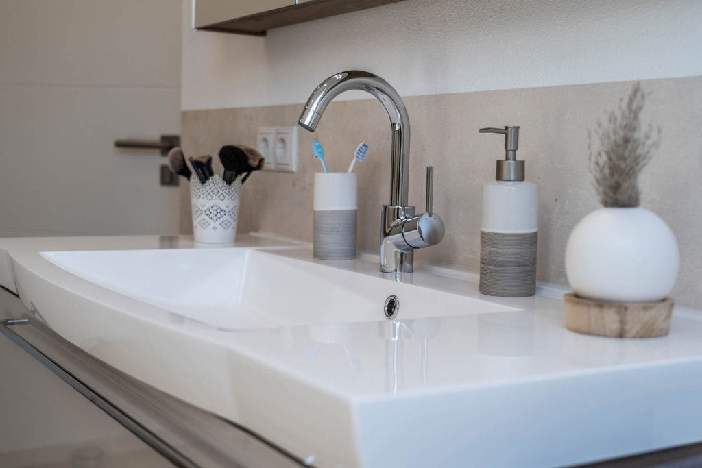 Waschbecken mit Bogenarmatur und Accessoires