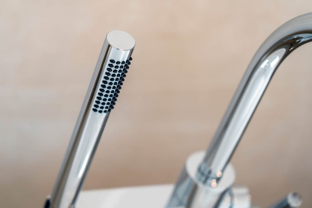 Detail der Stabhandbrause neben dem Wannenauslauf