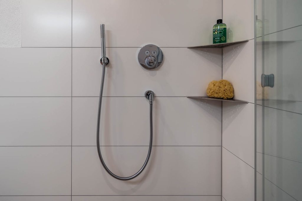 Handbrause, Thermostat und Eckablagen in der Dusche