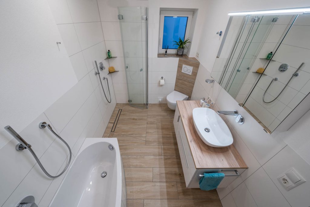 Draufsicht: Wanne, Waschtisch und Dusche im schmalen Bad