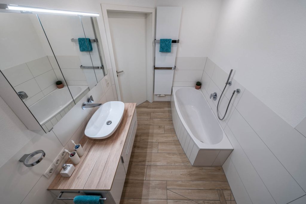 Blick von oben über Waschtisch und Wanne zur Badtür