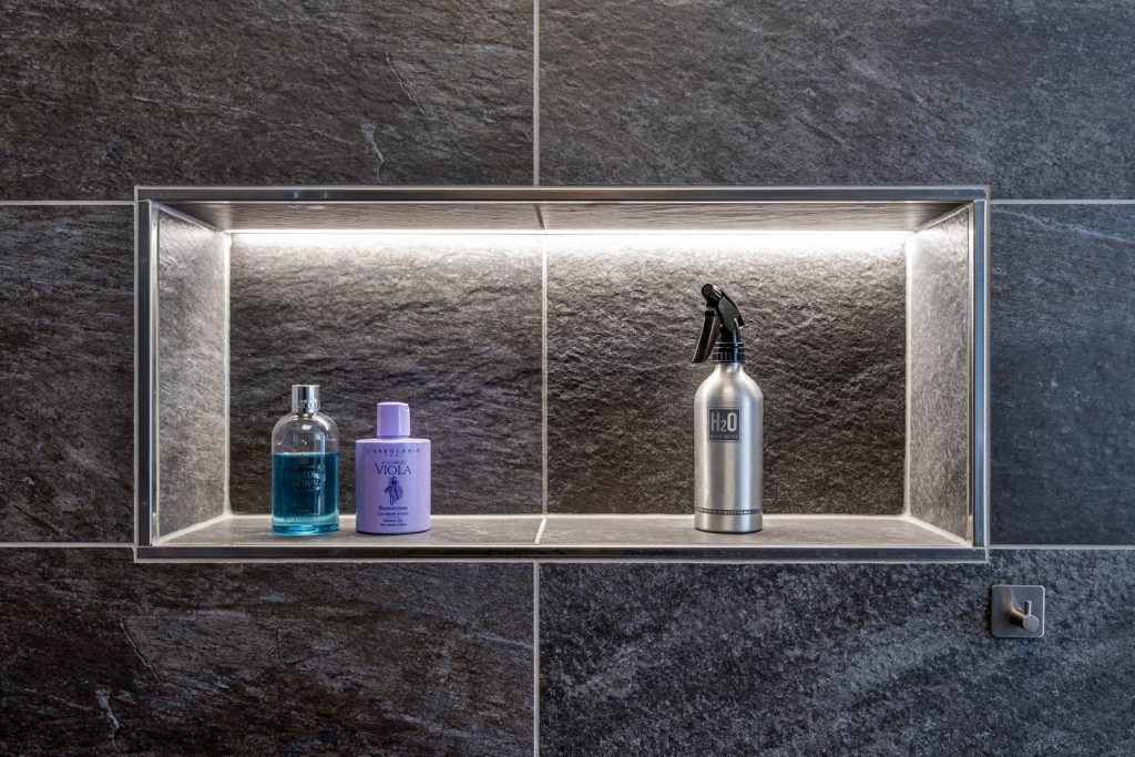 Beleuchtete Wandnische mit Pflegeprodukten in der Dusche