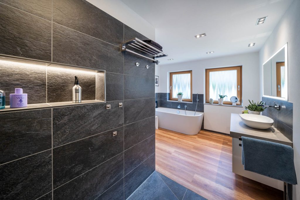 Dusche mit langer Lichtnische, im Hintergrund Wanne und Waschtisch