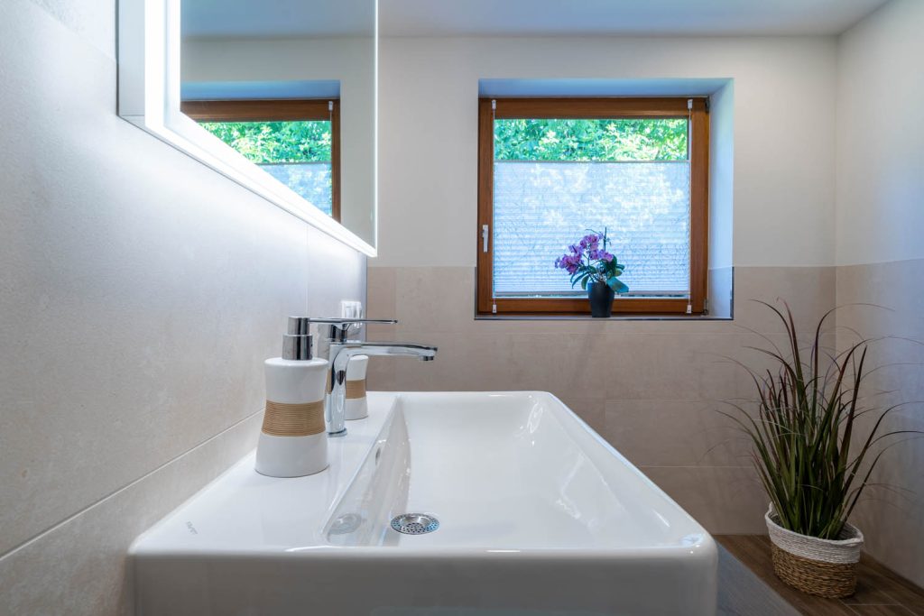 Waschbecken mit Seifenspender vor dem Fenster