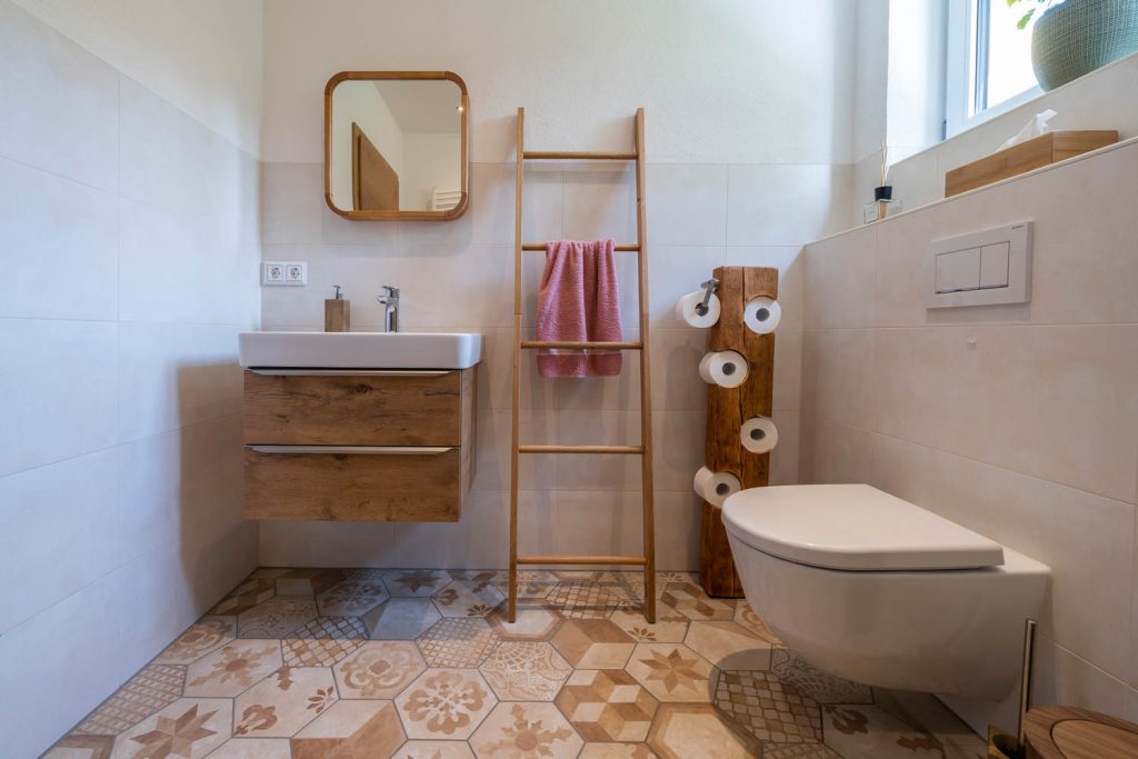 Waschtisch und Wand-WC über gemusterten Bodenfliesen