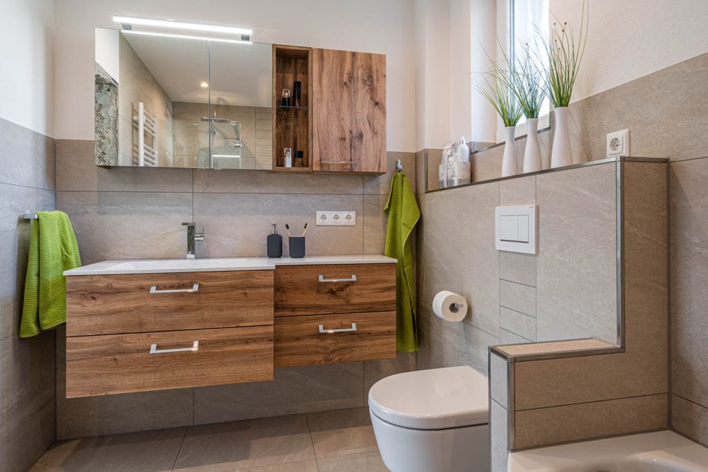 Waschtisch mit Schubladen und Spiegelschrank, rechts WC vor gefliester Vorwand