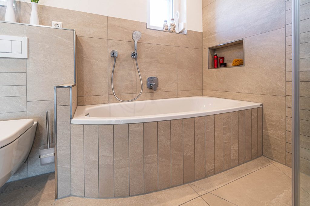 Eckbadewanne mit Handbrause und Wandnische