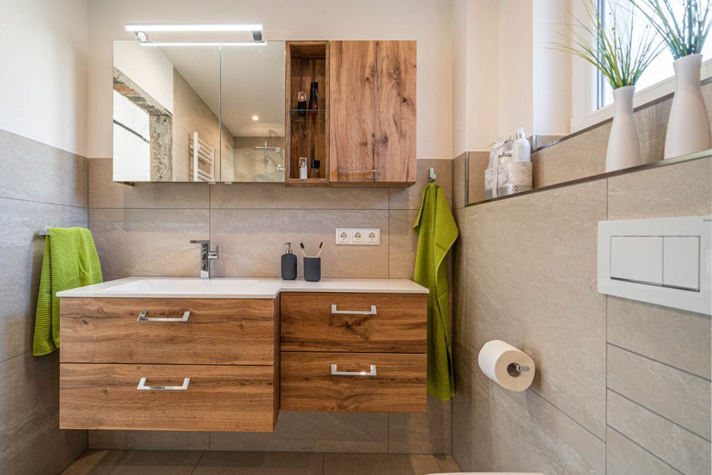 Waschtisch mit Spiegelschrank und Holzregal, rechts Papierhalter