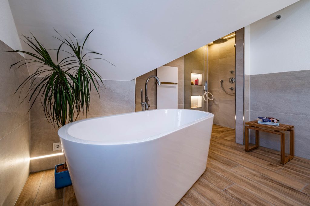 Freistehende Wanne unter der Schräge, hinten Dusche mit Lichtnischen