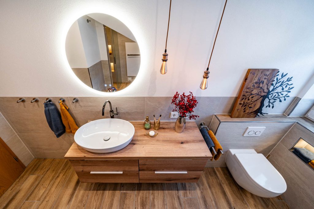 Waschtisch mit rundem Lichtspiegel und Wand-WC von oben