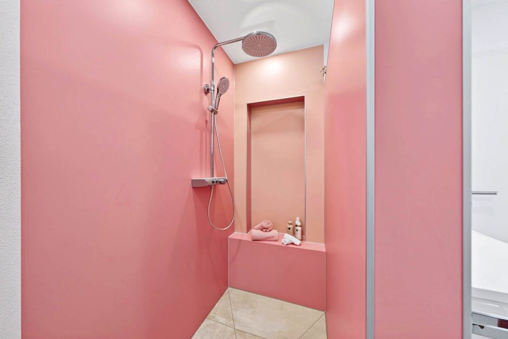Walk-in-Dusche in Rosé mit Sitzbank und apricotfarbener Wandnische