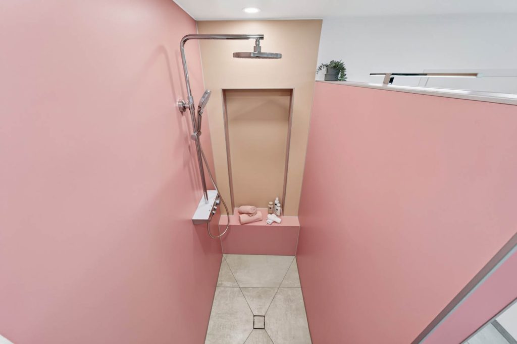 Begehbare Dusche mit Bodenablauf, Regenbrause und Sitzbank in der Nische