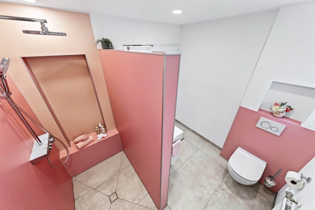 Blick von oben in die Dusche mit Sitzbank, rechts das Wand-WC