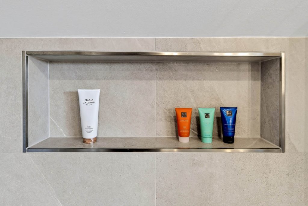 Wandnische mit Edelstahlrahmen und Pflegeprodukten in der Dusche