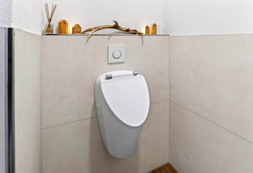 Urinal in der Nische mit Holzdeko auf der Vorwandablage