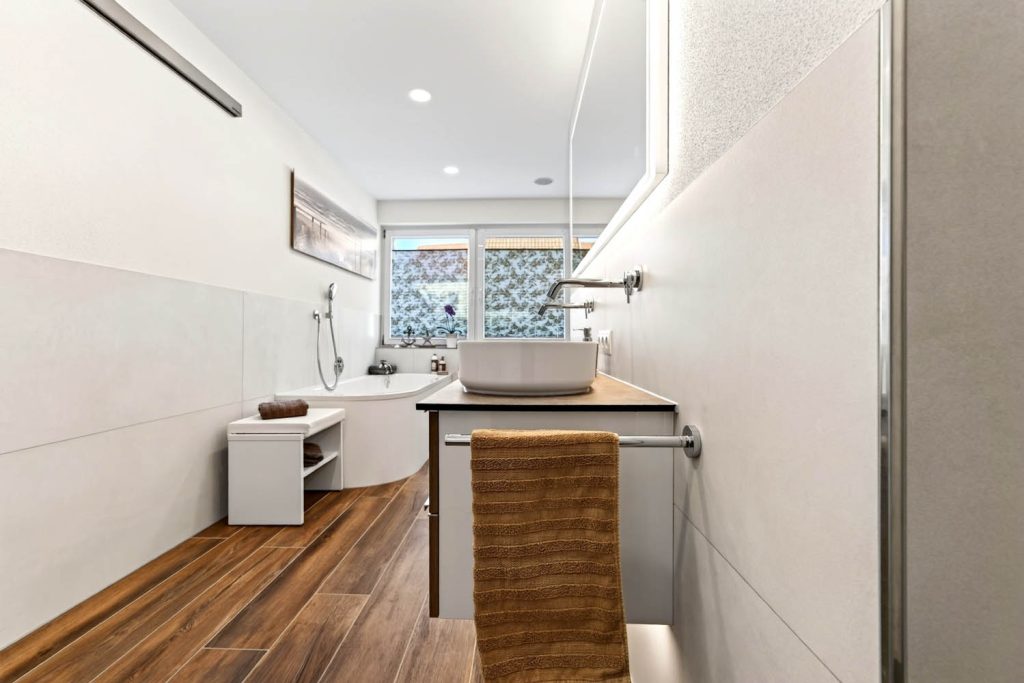 Blick am Waschtisch vorbei durch den langen Raum zur Badewanne