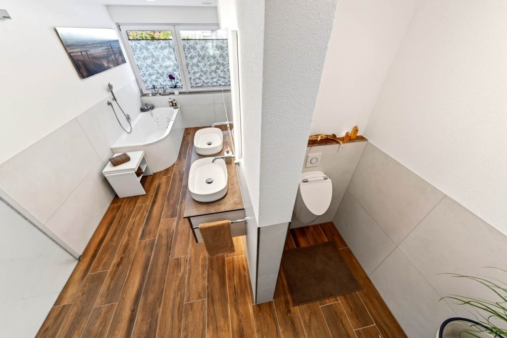 Draufsicht: Waschtisch, Badewanne und Urinalnische im langen Bad