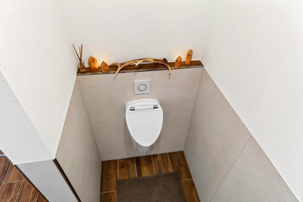 Draufsicht auf das Urinal in der Nische mit Holzboden