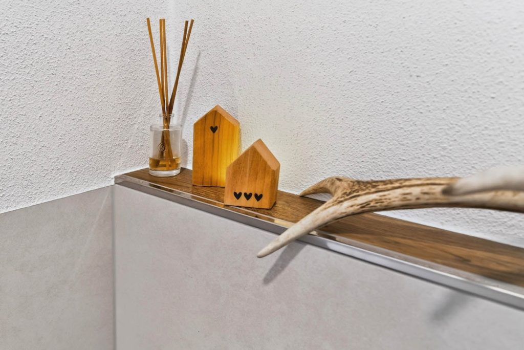 Deko aus Holz und Duftstäbchen auf der Vorwandablage
