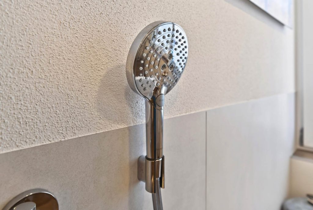 Handbrause in der Wandhalterung über der Badewanne