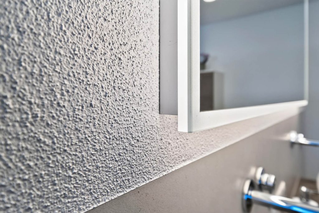 Strukturputz an der Wand neben dem Lichtspiegel
