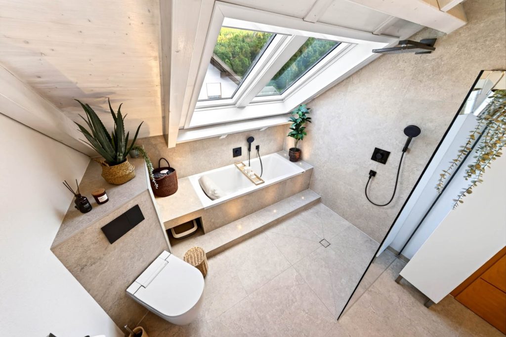Weitwinkel auf Dusch-WC, Badewanne und Dusche mit Glaswand