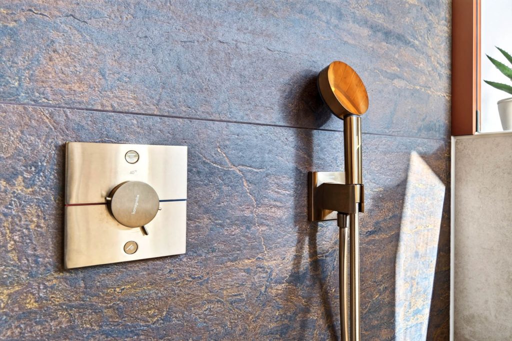 Seitliche Ansicht von Thermostat und Handbrause in Kupfer