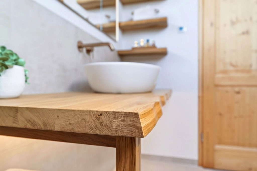 Detail der Baumkantenplatte mit Aufsatzbecken, rechts die Holztür