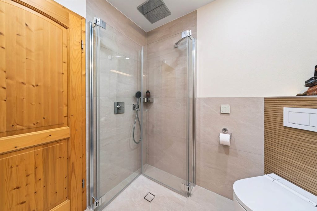 Bodengleiche Eckdusche mit Glastüren, rechts das Wand-WC